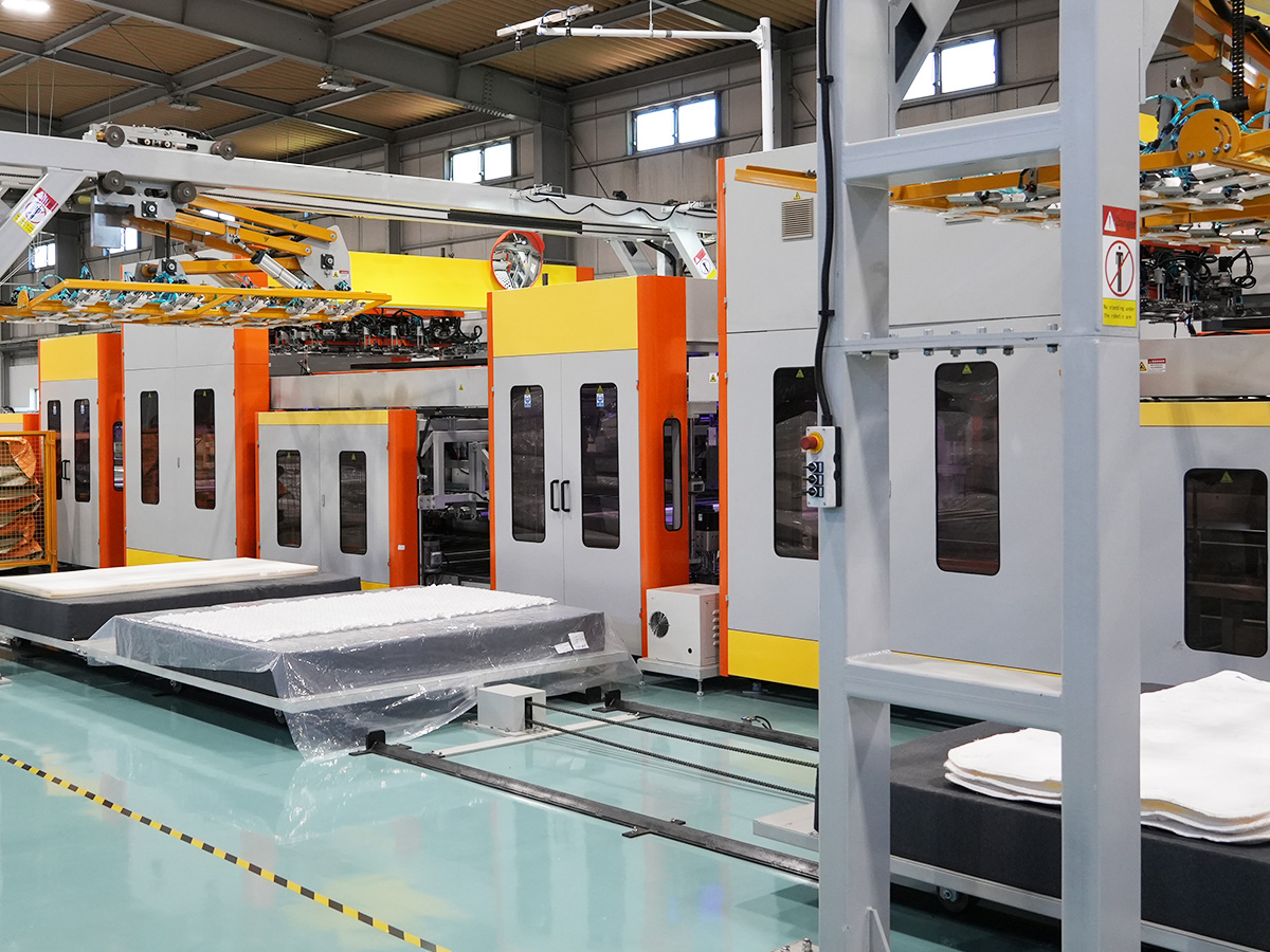 マットレス製造工場で作業するスタッフ